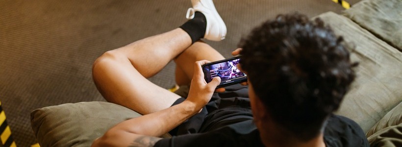 man playing game on mobile phone